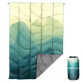 GLORSIGN waterproof puffy camping blanket laid out on grass, 55x79 inches