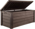 Keter Westwood 150 Gal outdoor storage box in brown on a patio holding pool cushions