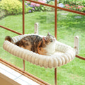 Cream white Zakkart foldable cat window perch attached to a window with suction cups