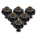 Twelve black ceramic pumpkin-shaped cabinet knobs displayed on white background