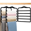 Three space-saving pants hangers hanging in a closet