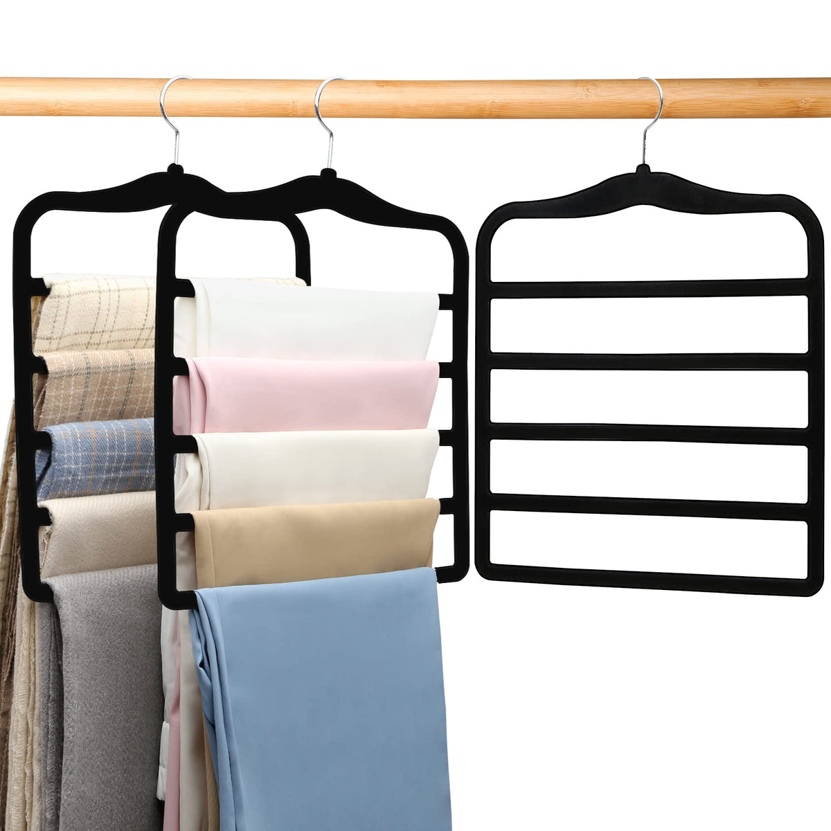 Three space-saving pants hangers hanging in a closet