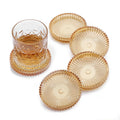 Five amber clear round glass drink coasters stacked on a white surface
