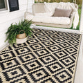 Black and beige reversible 5x8 waterproof outdoor rug on a patio